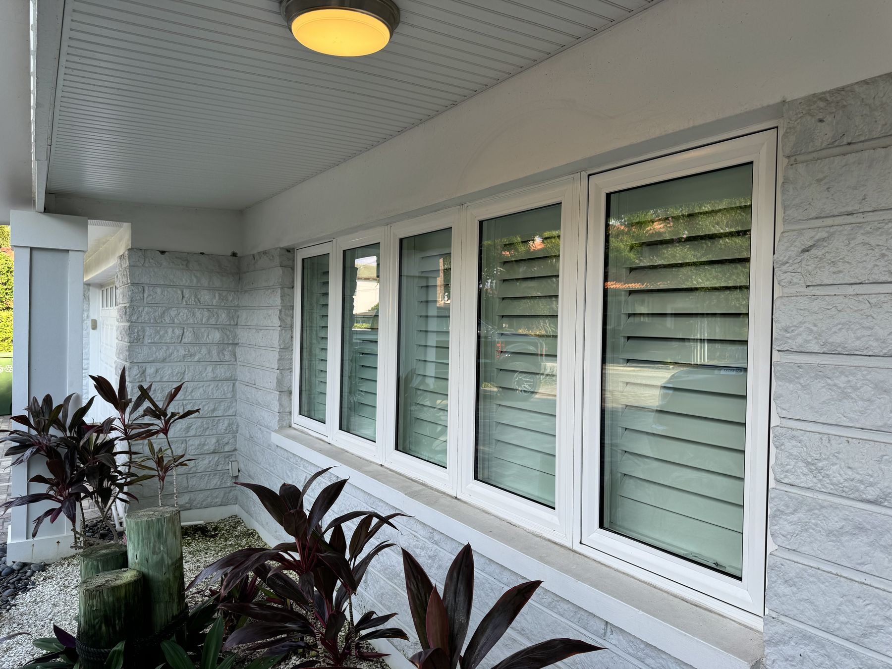 Freshly cleaned casement windows along a covered front porch
