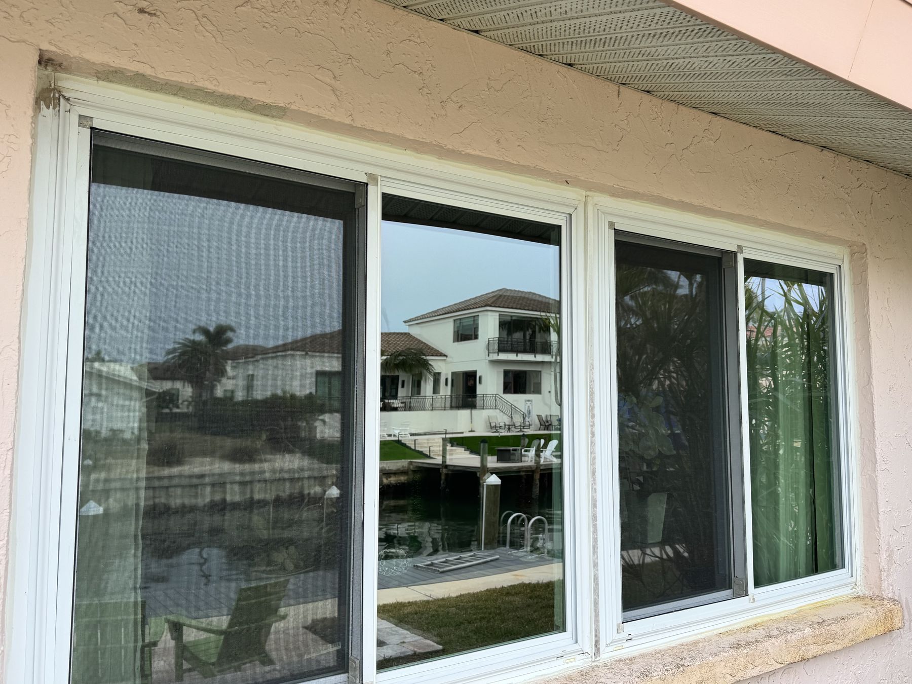 Waterfront sliding windows and screens overlooking a canal